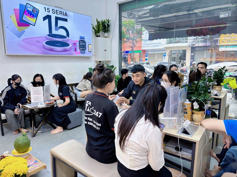 Khách hàng đang mua và tư vấn iPhone tại cửa hàng Táo 247, không gian đông đúc và chuyên nghiệp