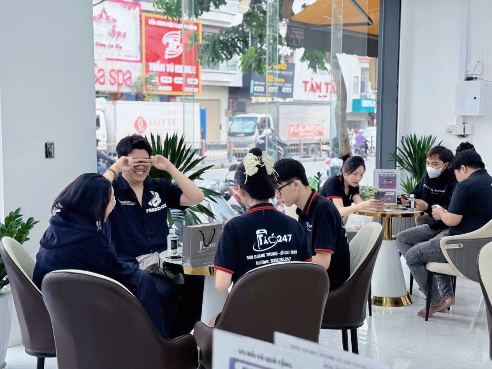 Nhân viên cửa hàng Táo 247 đang tư vấn và sửa chữa iPhone cho khách trong không gian chuyên nghiệp
