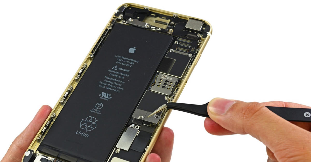 Kỹ thuật viên Táo 247 đang đo đạc bo mạch để sửa phần cứng iPhone mất sóng trên bàn máy móc hiện đại.